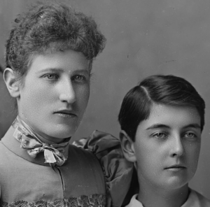 Close-up of a Victorian photograph of a woman and boy, featuring retouching scratches on their faces.